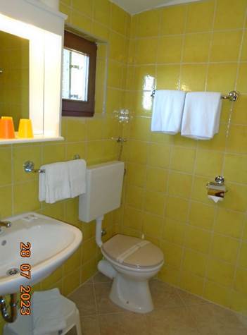 A bathroom with yellow tiles

Description automatically generated