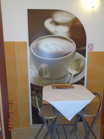 A table and chair with a picture of a coffee cup

Description automatically generated